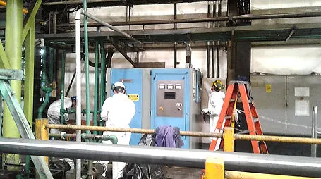 Operarios en planta con panel de control